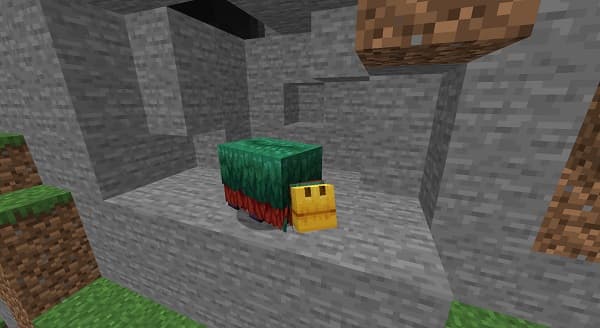 A young woman in a denim jacket and white shirt smiles, holding a modern smartphone in a stylish cafe.