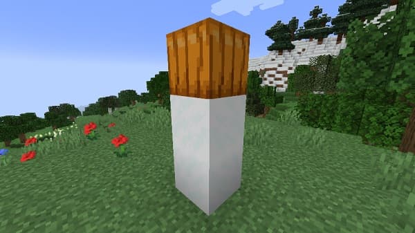 A large, fluffy white dog lying on a gray couch, looking towards the right.