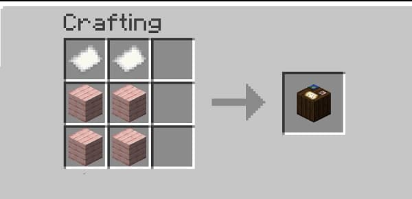 Black laptop on a white desk with a plant.