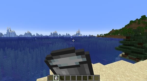 A white dog on a leash walking through a grassy park.