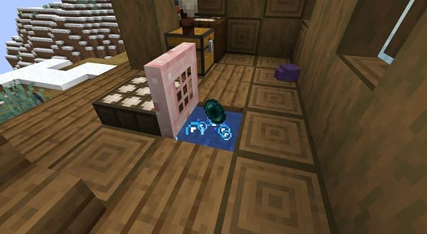 A pile of fluffy brown dog fur and a brush on a wooden floor.