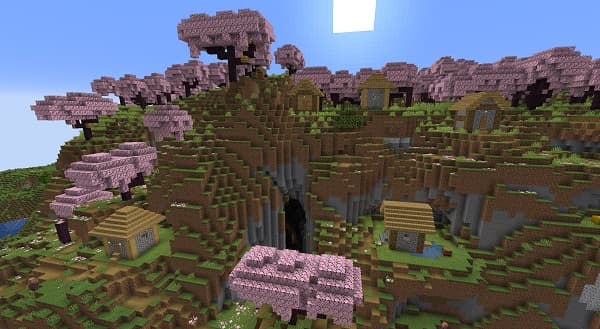 A lone tree stands majestically in a golden field under a vast, cloudy sky.