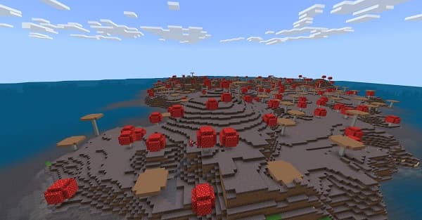 A lush, green meadow with trees in the background under a blue sky.