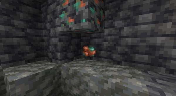 A close-up shot of a white ceramic plate with a gold rim on a dark, textured surface.