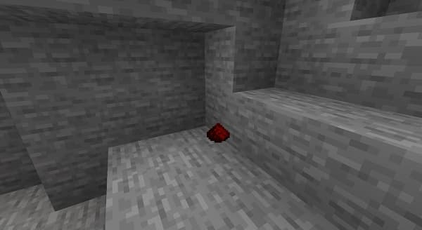 An empty room with white walls and a light wood floor.