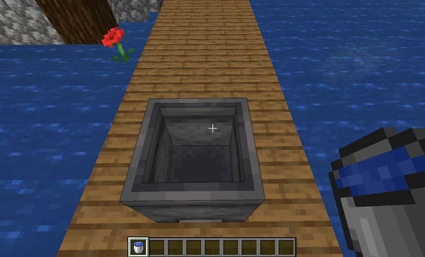 A hand holding a glass of amber liquid, possibly whiskey or brandy.