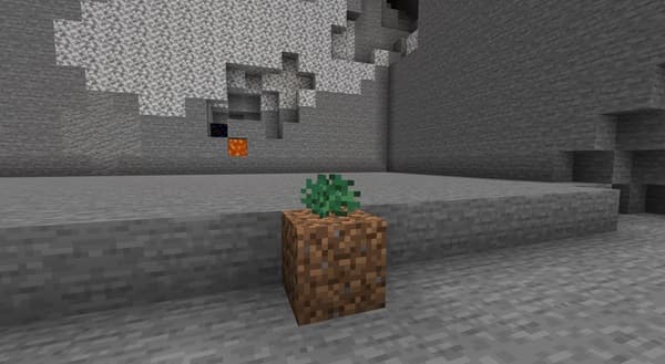 A person's hands holding a green smoothie in a glass jar.