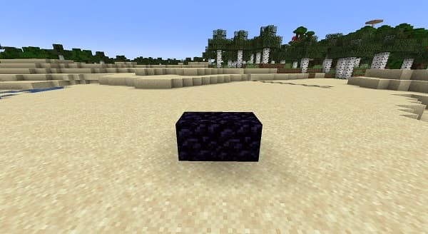 A lone black dog with a tennis ball in its mouth, standing on a grassy field.