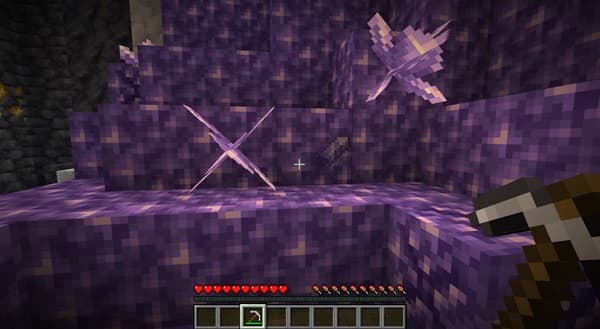 A large, fluffy white dog lying on a brown blanket with a tennis ball near its paw.