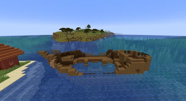 A sleek silver car drives on a winding road through a lush green landscape.