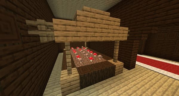 A small, gray robot with a camera lens for an eye, standing on a textured surface.