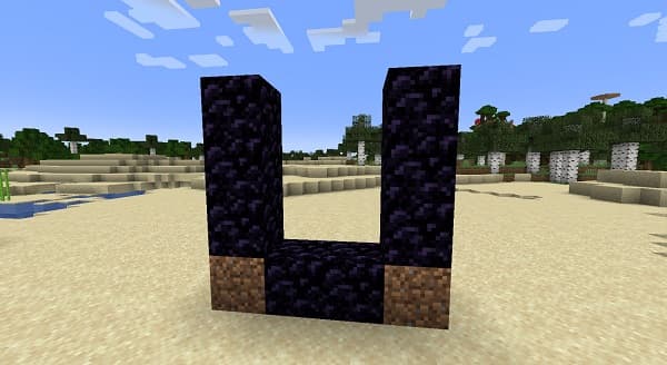 A person in a black coat and red pants sits on the ground looking at a phone.