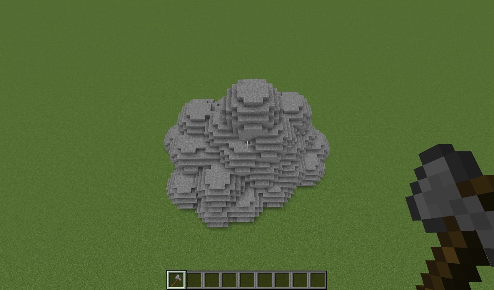 A person's hand holding a single, vibrant green avocado.