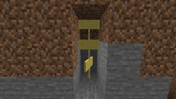 A young woman with an afro sits in a vibrant yellow room, smiling directly at the camera.