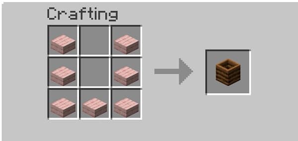 A serene image of a bright red barn, partially obscured by lush green trees, under a blue sky.