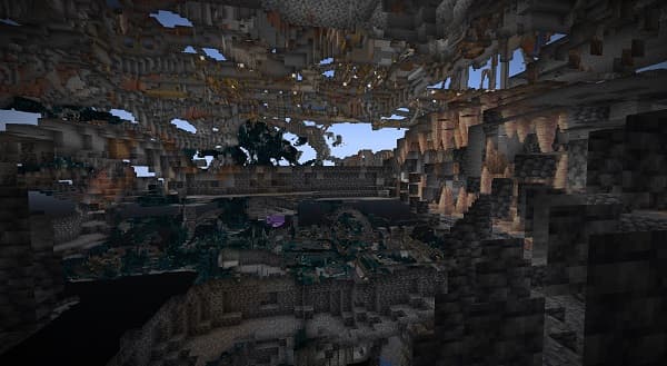 A person wearing glasses uses a laptop in a cafe.