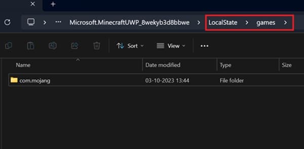A close-up shot of a small, vibrant green plant with tiny leaves, growing from dark soil.