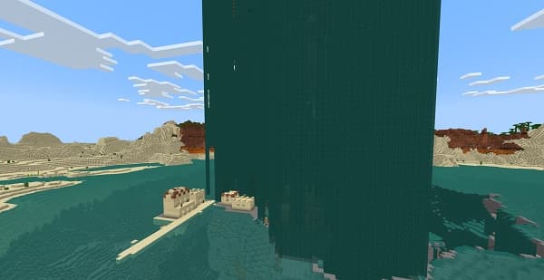 Two empty wooden benches sit side-by-side in a tranquil, sunlit park.