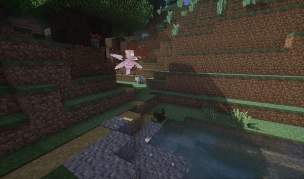 A serene river flows through a dense forest under a clear sky.