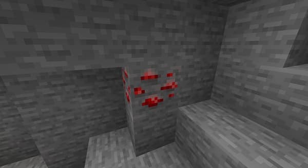 A young man in a white t-shirt and glasses smiles.