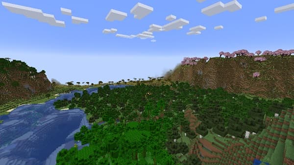 A person’s hand holds a small glass bottle with a clear liquid.