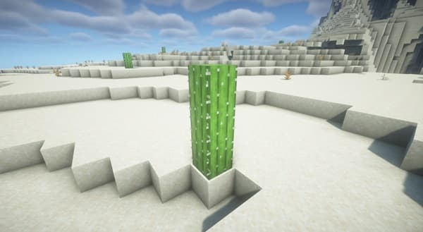 A person using a laptop and phone on a modern wooden desk.