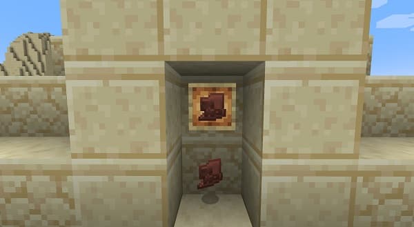 A close-up of a vibrant red flower with delicate petals and a yellow center, set against a soft, blurred green background.